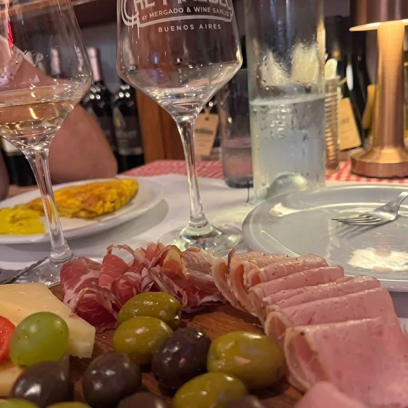 Picada con fiambres y aceitunas y una copa de Che Malbec